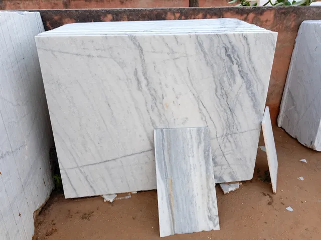 Veined white marble slabs and matching sample — enhanced business photograph
