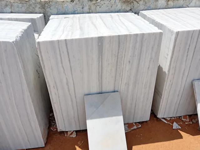 Light veined marble tiles with sample piece — enhanced business photograph